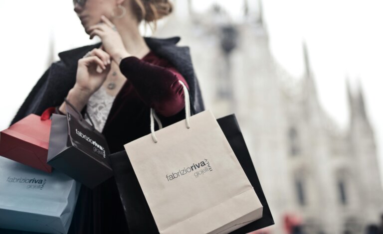 A woman holding multiple shopping bags, symbolizing shopping addiction, impulse buying, and the struggle for self-control