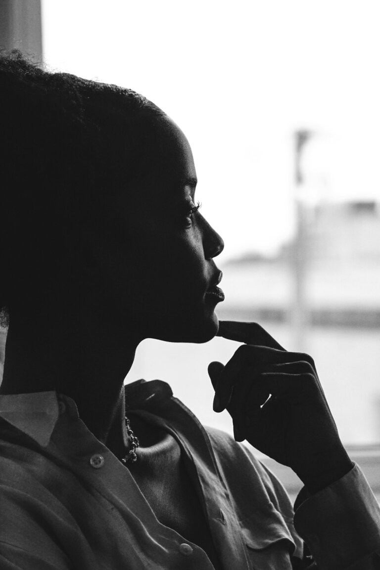 Person stressed looking out the window feeling overwhelmed, stress