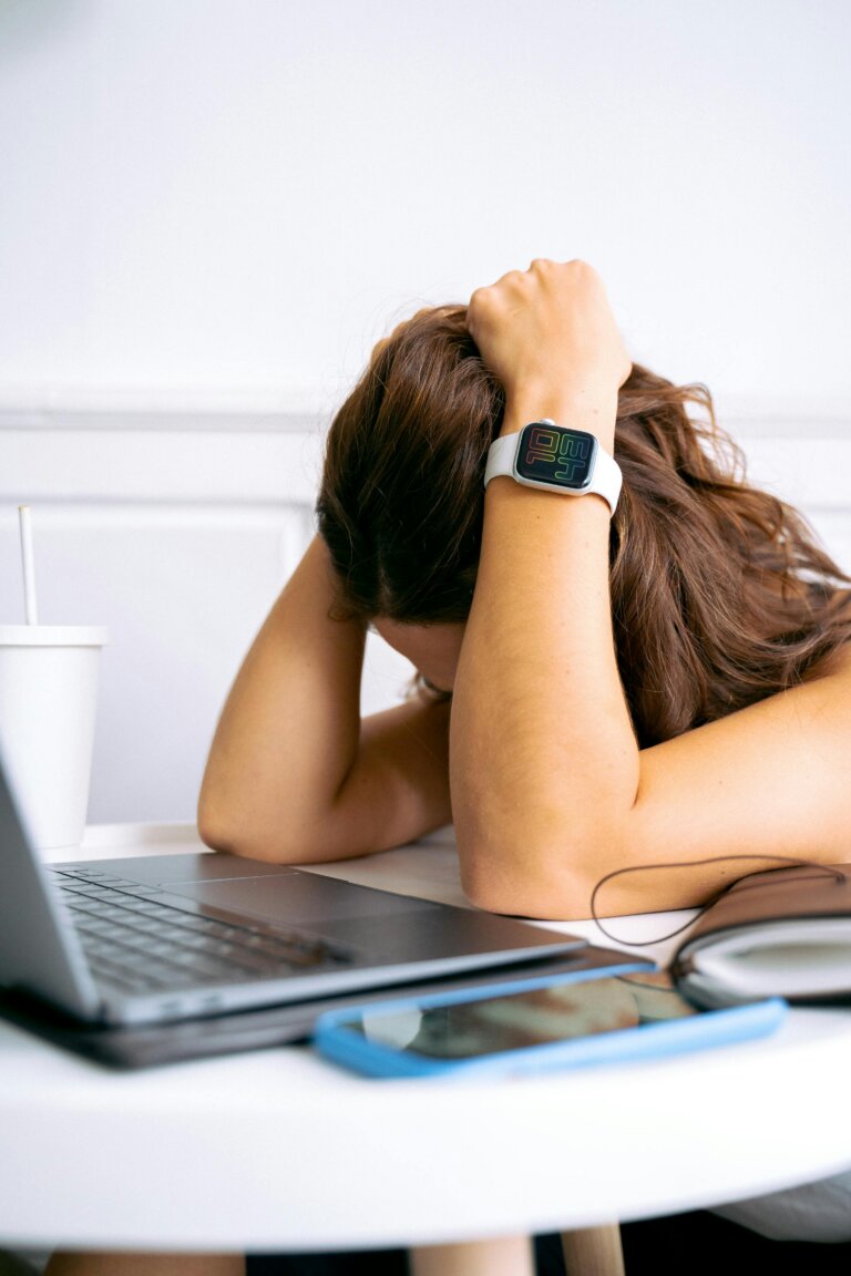 Depressed woman sitting in front of a laptop, feeling stressed and overwhelmed