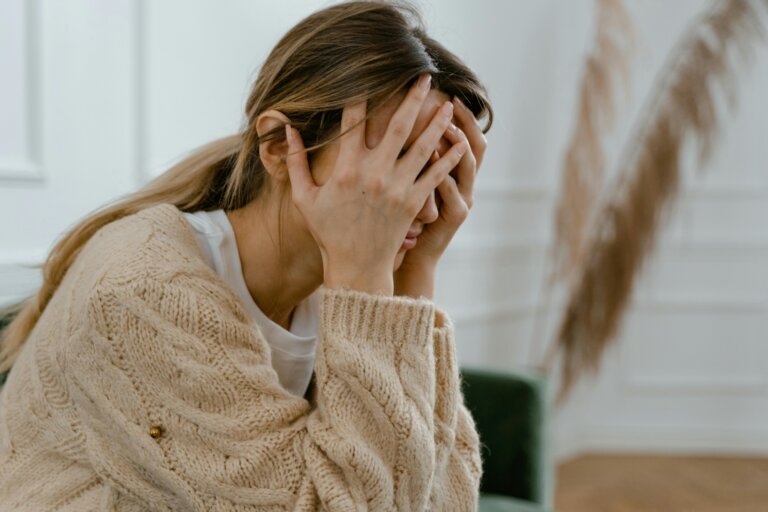 Depressed woman holding her head, feeling overwhelmed and sad