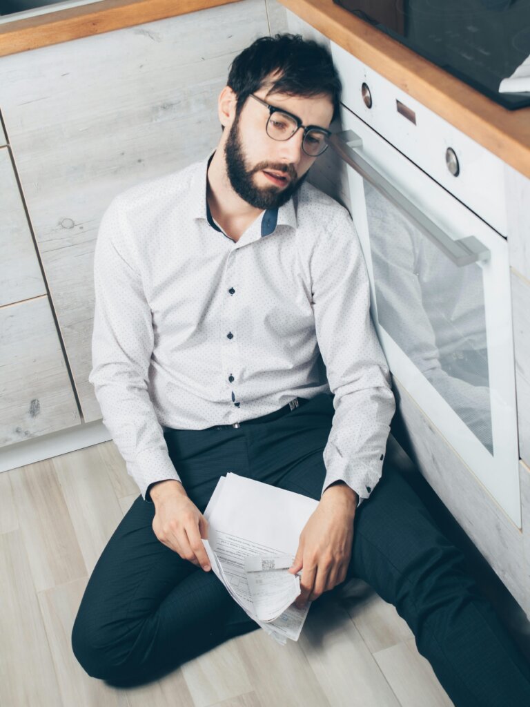 Tired office worker sitting at a desk feeling exhausted, chronic fatigue from work stress