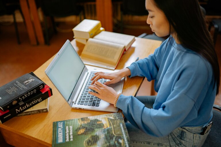Student sitting at a desk with books and study materials focused on studying