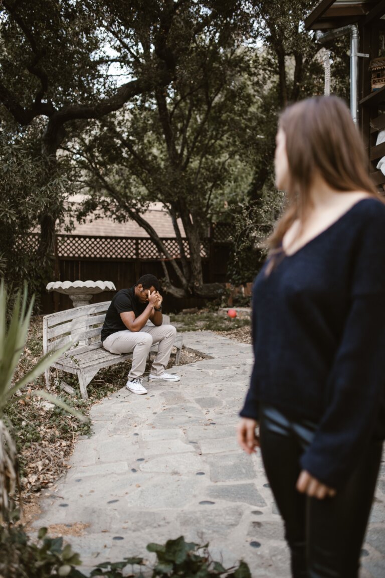 Woman walking away while a man looks after her, representing jealousy, insecurity, and trust issues